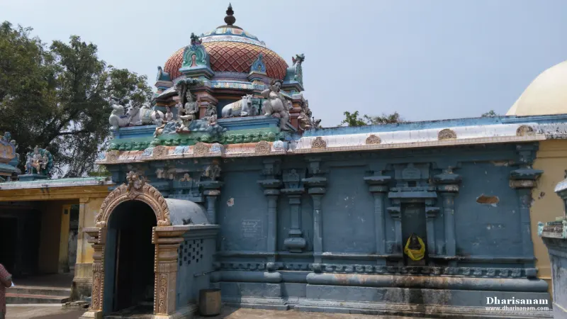 A long blue stone wall with a domed top and an arched entrance at its left end