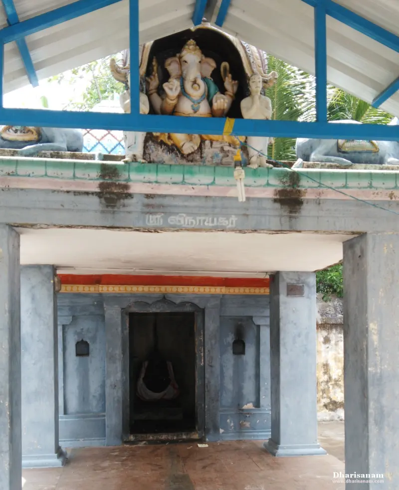 A shrine under a roof, with a painted Ganesha figure above and a Tamil name board below
