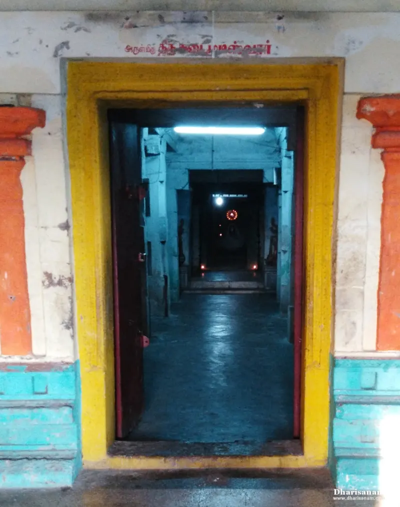 A yellow door frame opening onto a dim corridor, with small lamps glowing in the distance