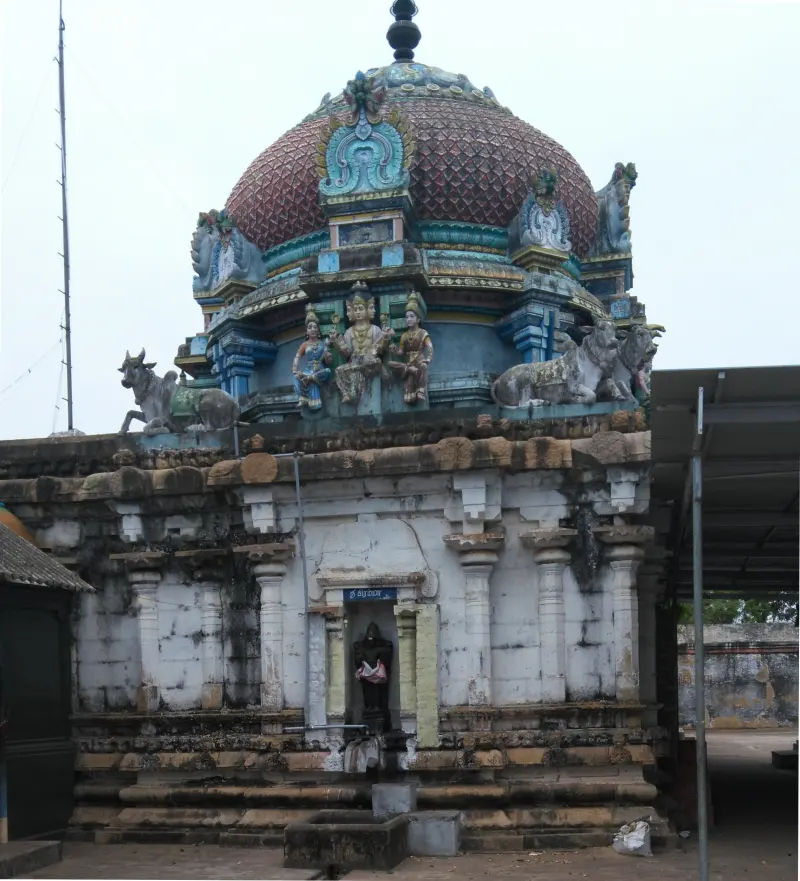 A domed shrine roof with painted figures, and a small deity figure in a niche in its wall.