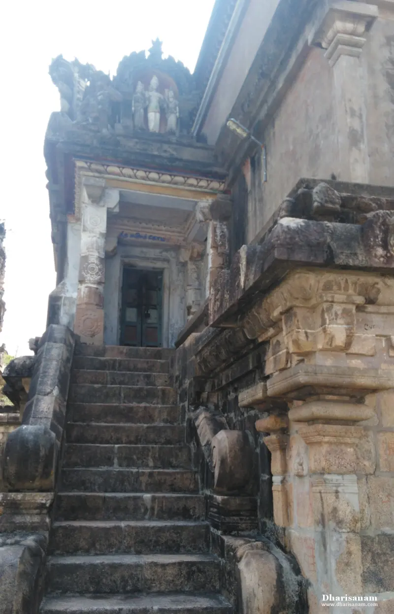 A steep flight of stone steps leading to a small doorway with figures on the roof above