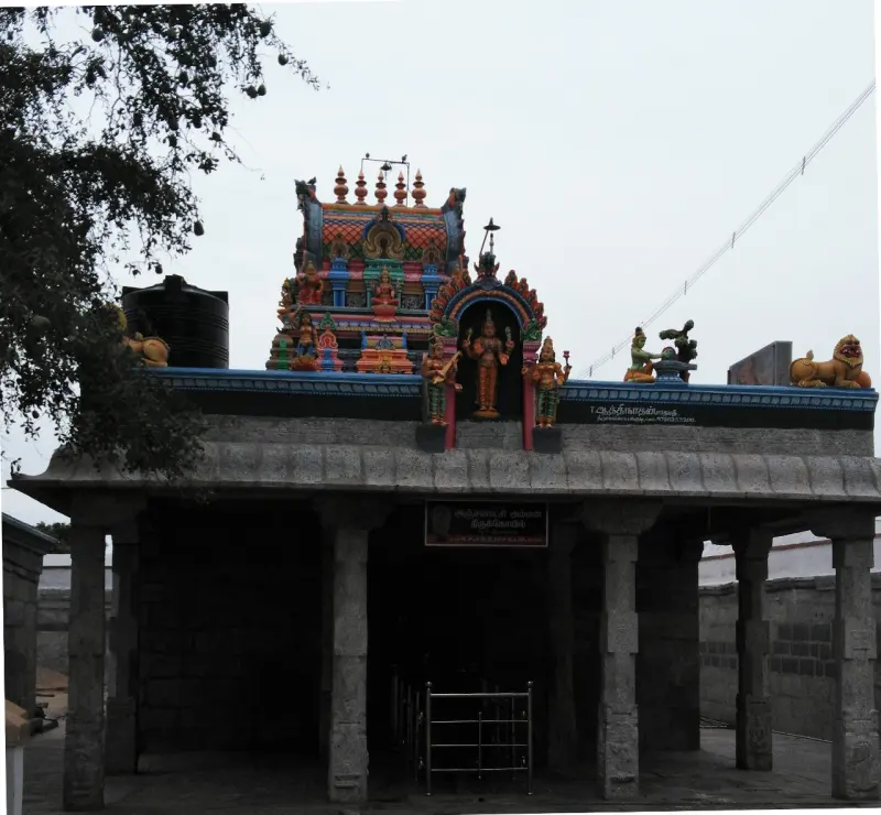 Stone pillared entrance below a small tower with painted deities and lions