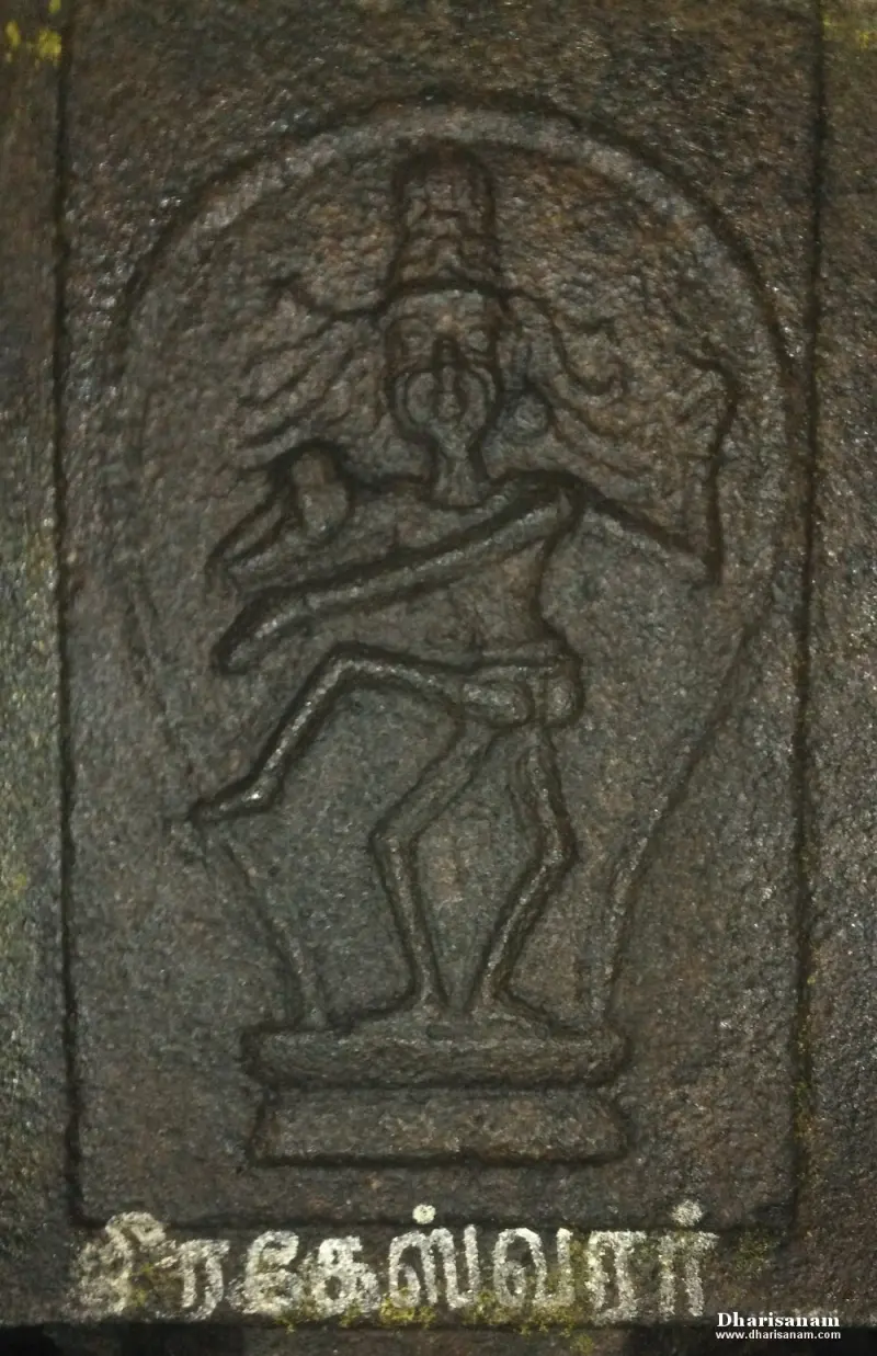 A carved relief of a figure with one raised leg, with a Tamil name painted below it.