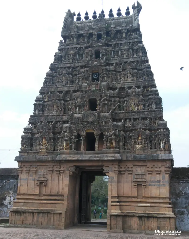 A tall, many-tiered gateway tower covered in sculpture, with a doorway at its base