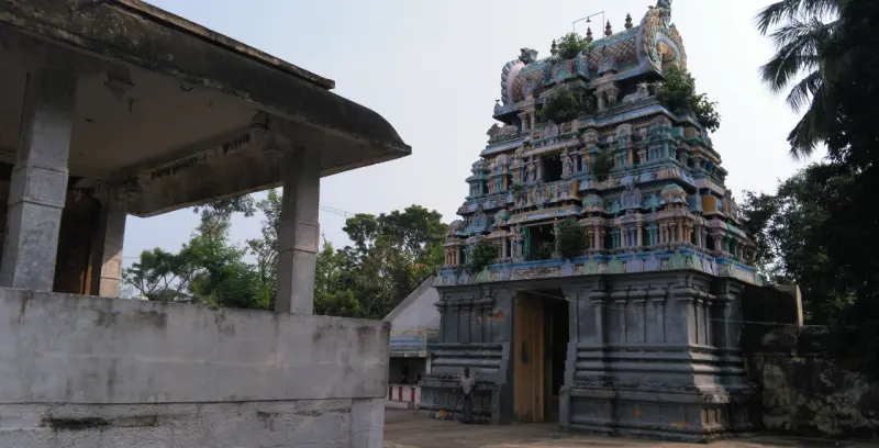 The tall gopuram seen from the courtyard beside a hall