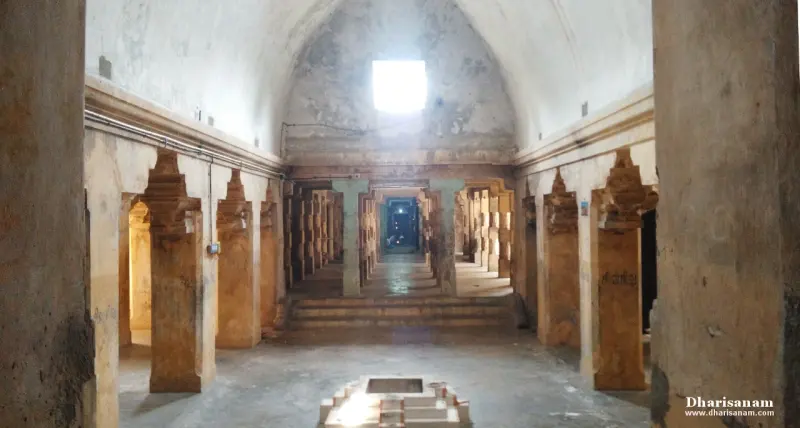 A long vaulted hall with pillars along both sides, a raised stone platform in front and a skylight above