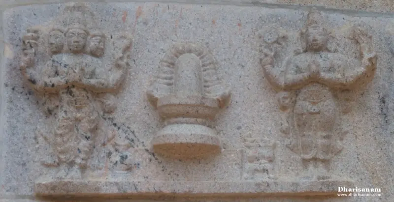 Stone relief of two gods with folded hands around a central lingam