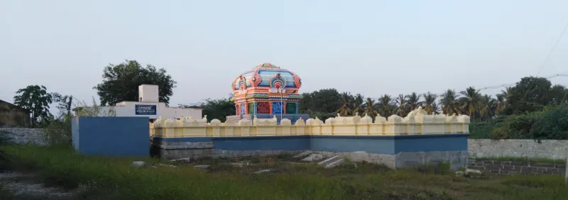 A small colorful temple with blue walls standing in a field