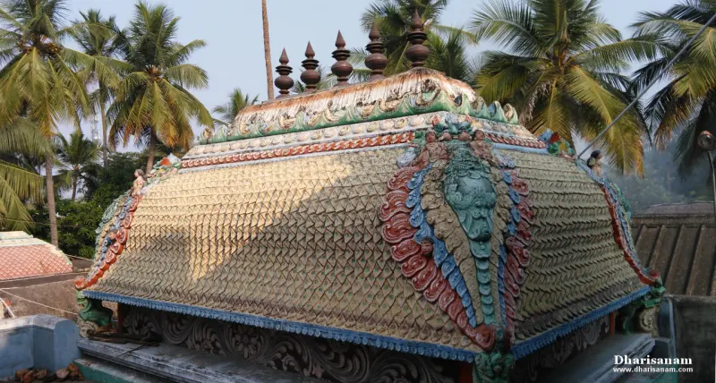 Close view of a tiled shrine roof with a carved face