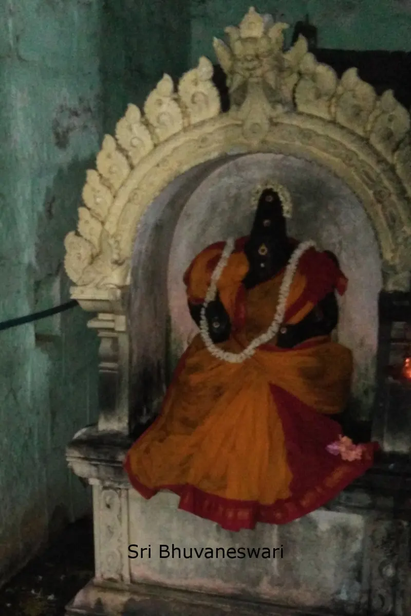 A seated goddess in an orange and red cloth with a flower garland, under a carved arch; a caption names her.