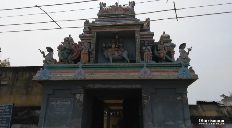 A tiered gateway with colourful figures, among them a seated bull, above a dark passage
