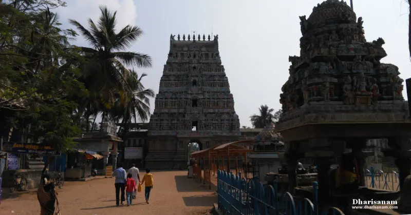 A stepped stone tower beyond a sandy path, with a carved shrine roof on the right