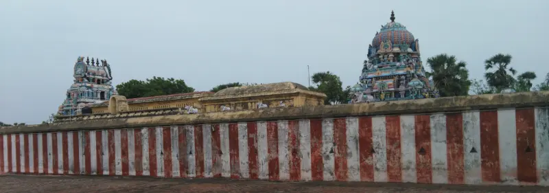 Red and white striped wall in front, with two towers rising behind it