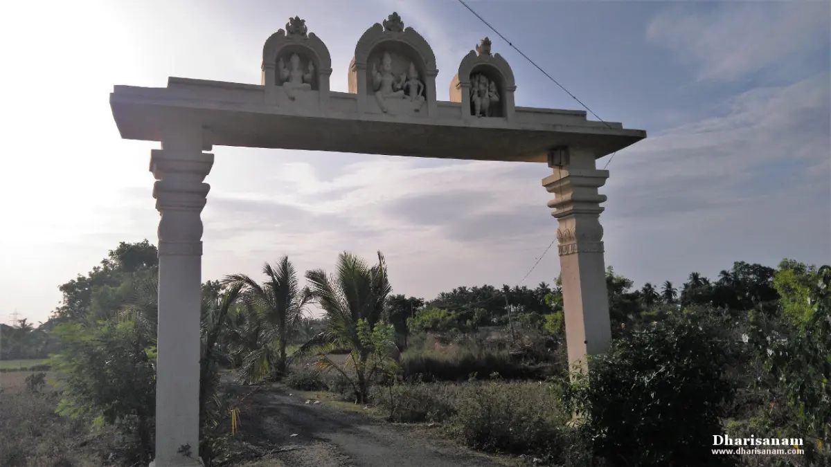 A stone arch with deity niches over a rural path