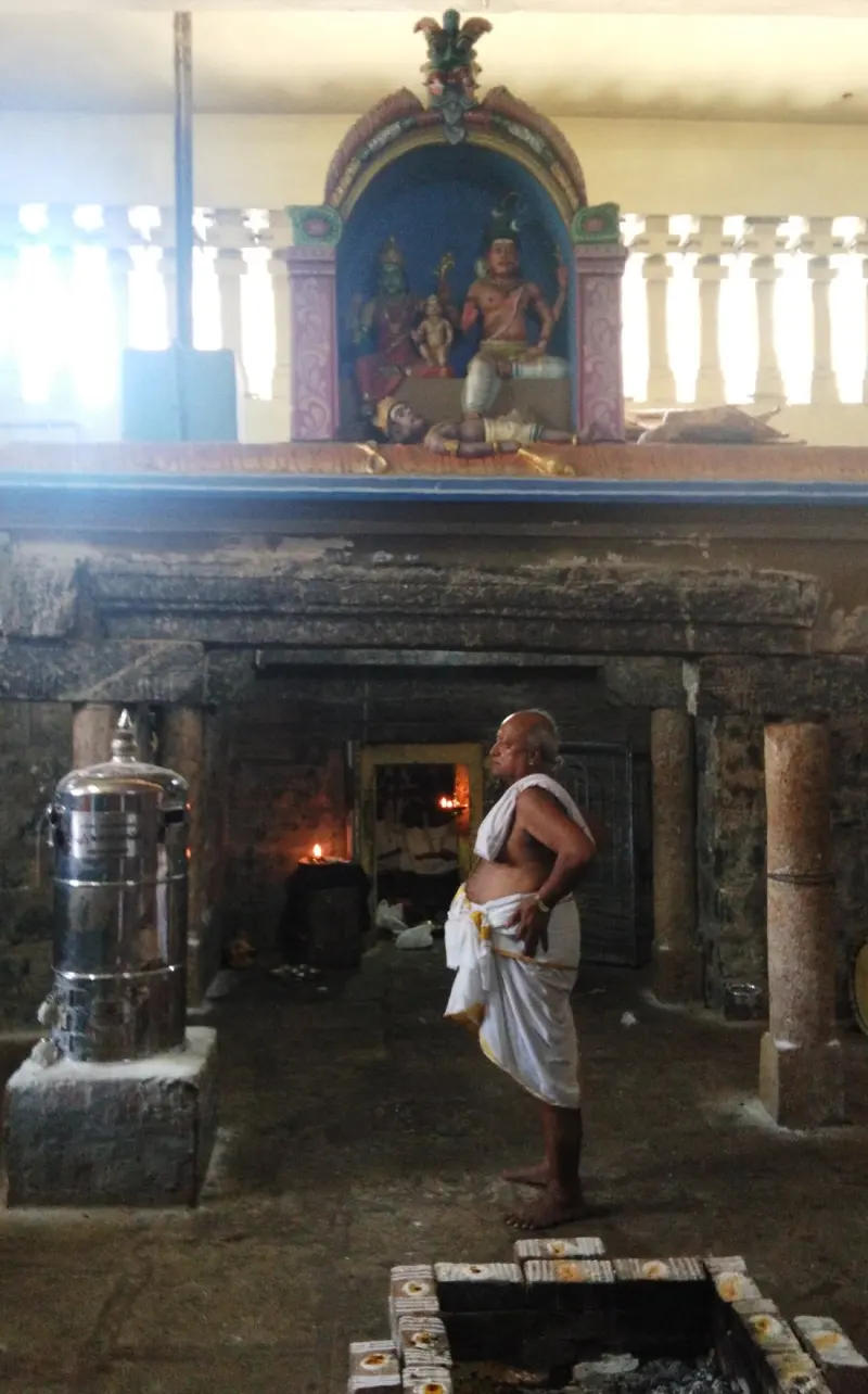 A niche above the doorway holds idols of Lord Shiva and Goddess Parvathi with a child, and a figure lying below.