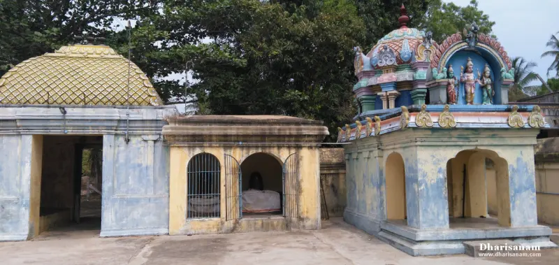 Small domed shrines with barred windows beside a blue shrine topped with three painted figures