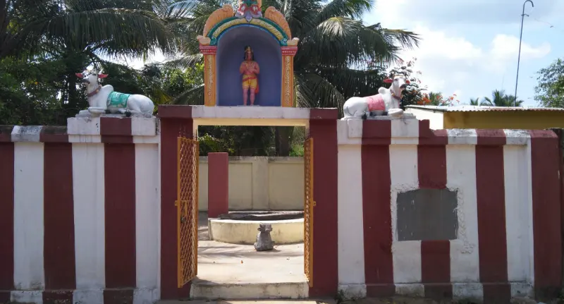 A red and white striped gateway with white bulls on both sides and a Nandi inside