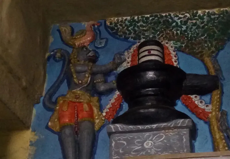 Painted panel of a monkey-faced Hanuman beside a black lingam, with a tree painted behind