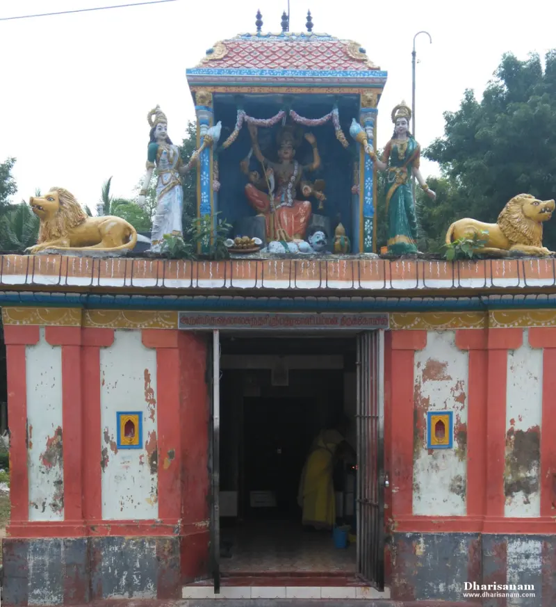 A red and white shrine front with a goddess figure flanked by two women and two lions above the doorway