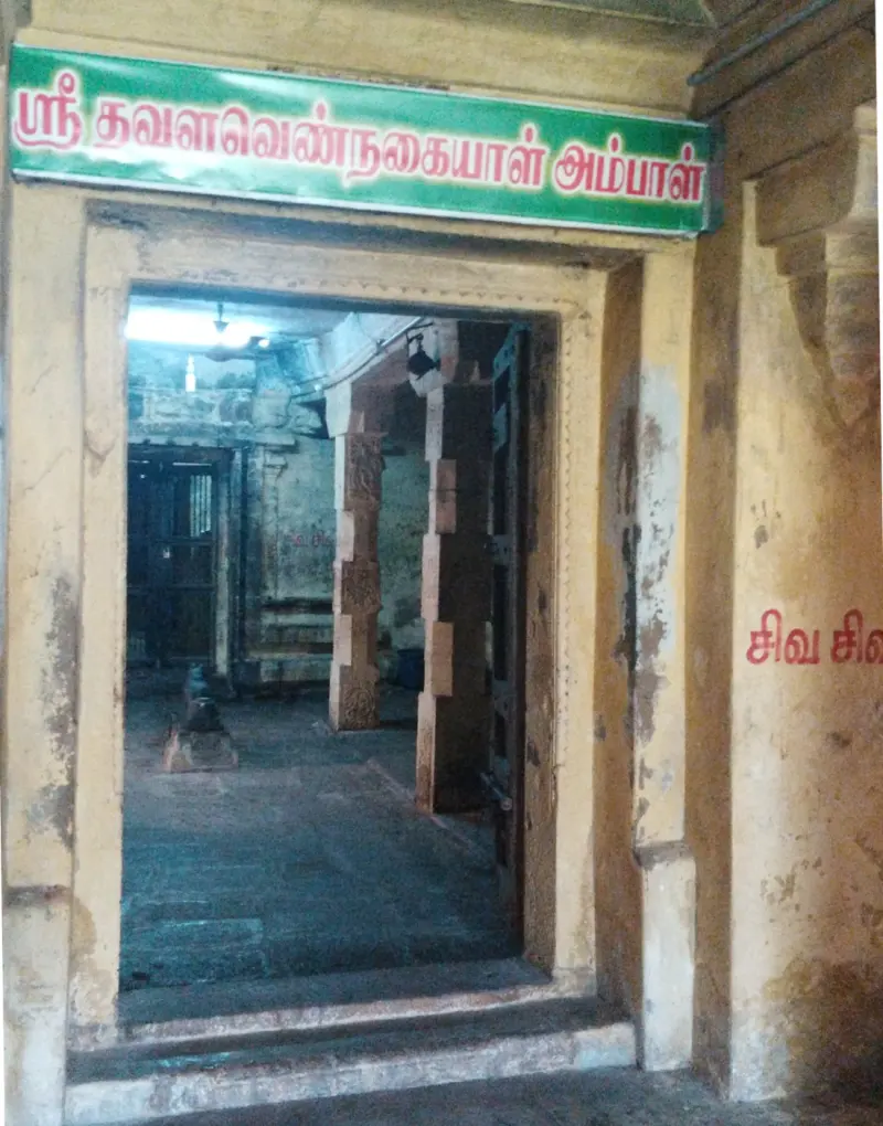 A doorway under a green Tamil name board of the goddess shrine