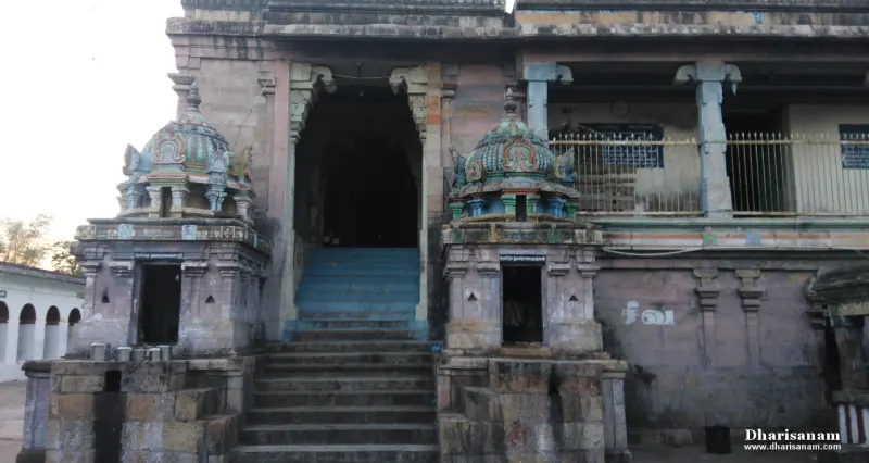 A wide flight of steps rises to a dark doorway, between two small shrines with coloured domes