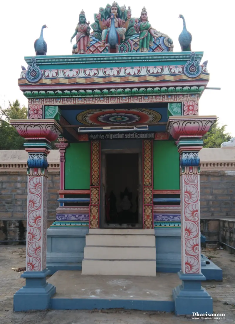 Small shrine painted blue, green and red with steps and two peacock figures on the roof