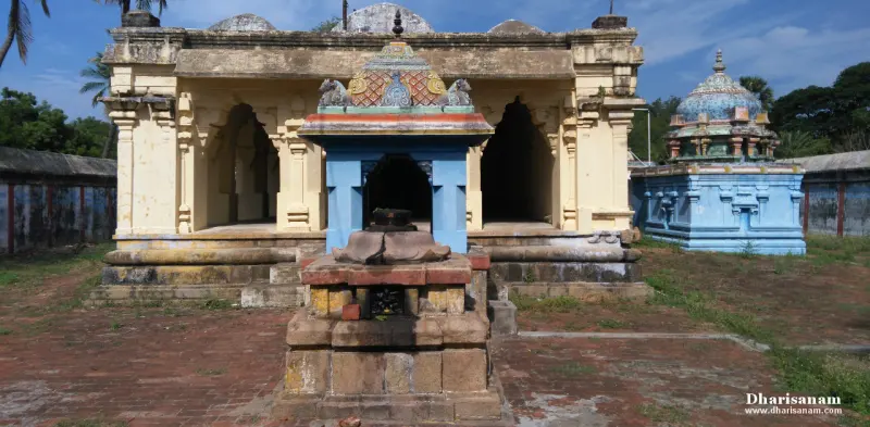Stone pedestal with a Nandi under a blue canopy in front of a pillared hall, and a blue shrine at the right