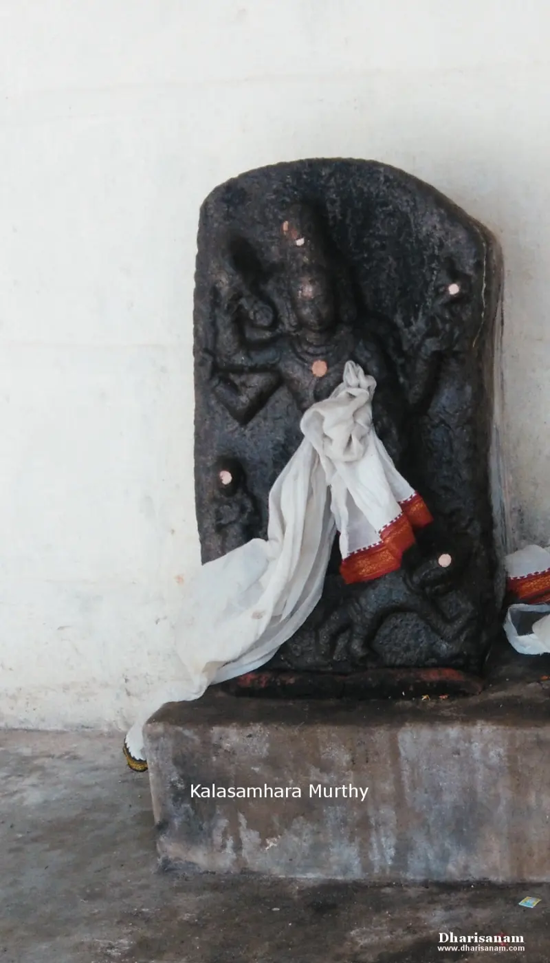 A carved dark stone panel with a figure draped in white cloth, labelled Kalasamhara Murthy