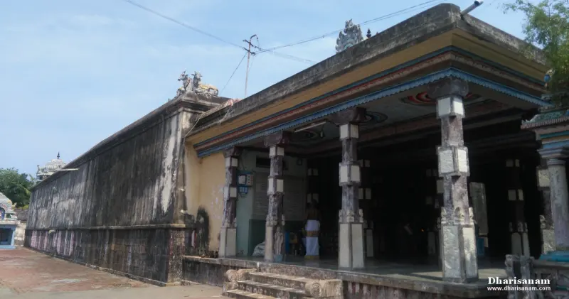 Open hall with square stone pillars and a painted ceiling edge, beside the outer wall
