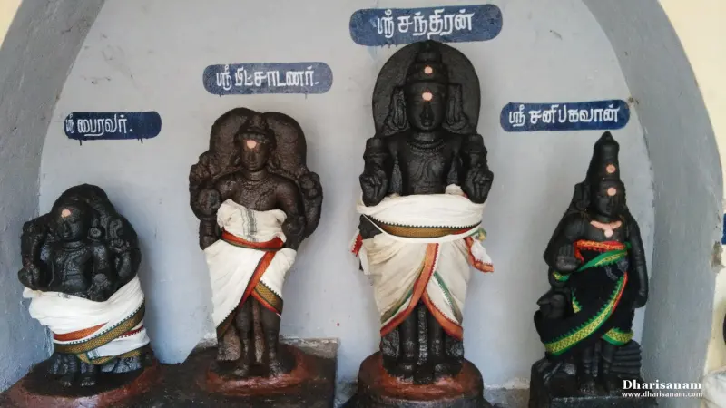 Four dark idols in white cloths with Tamil name boards