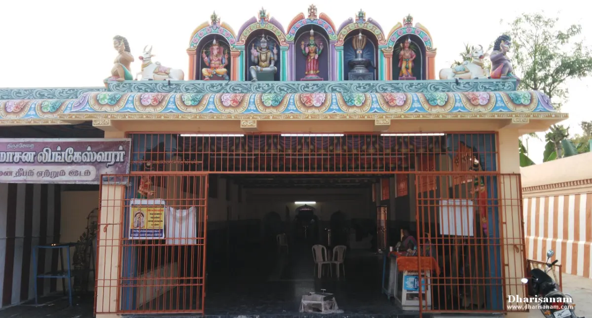 A shrine front with painted figures on the roof and a red iron grille at the entrance