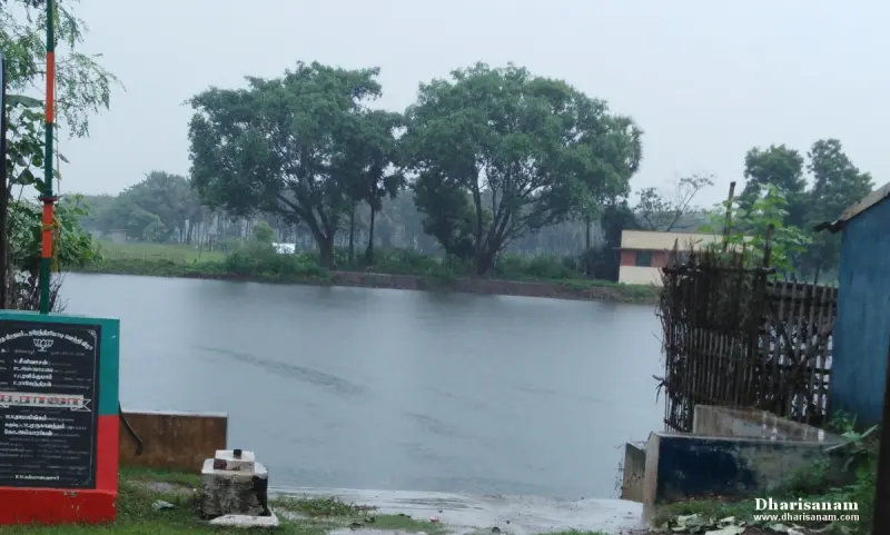 A tank with still water, trees on the far bank and a notice board at the left