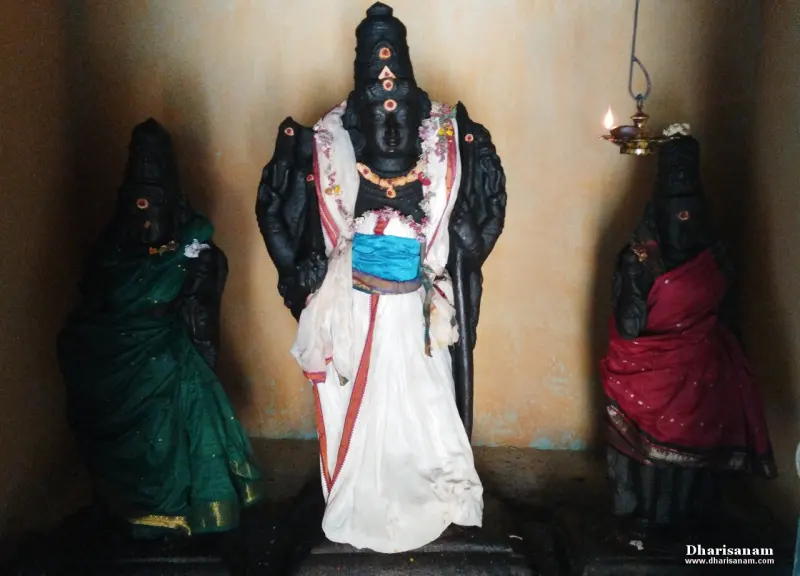 Tall central idol in white cloth flanked by two smaller draped idols
