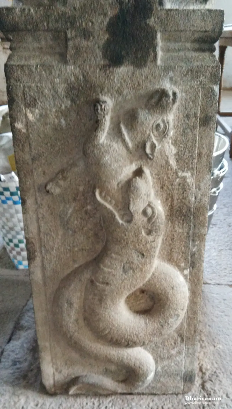 Stone pillar relief of two snakes facing each other, one coiled below