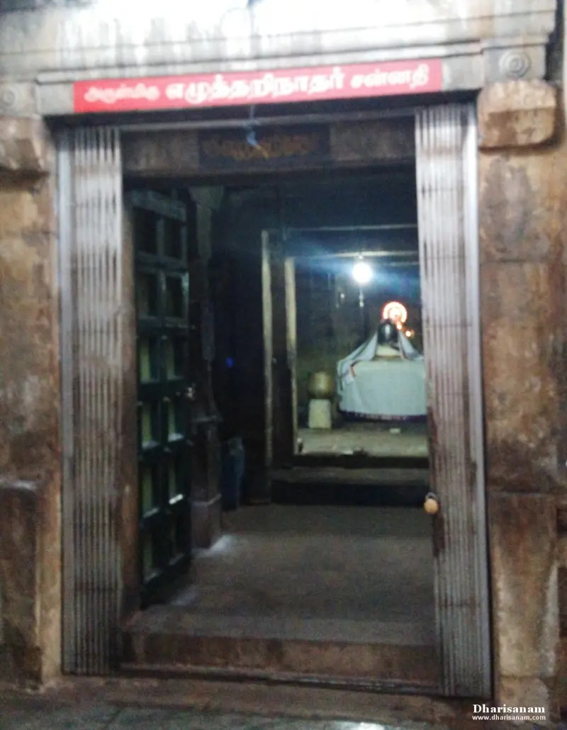 Stone doorway with a red name board; the sanctum is seen dimly inside