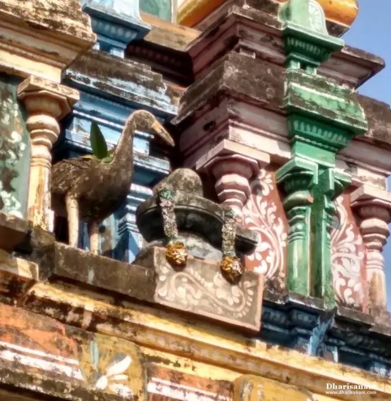 A crane sculpture beside a small Shivalingam on the tower