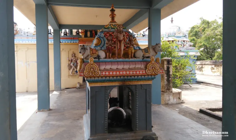 A small colourful shrine in a pillared hall, with a dark bull figure inside its opening