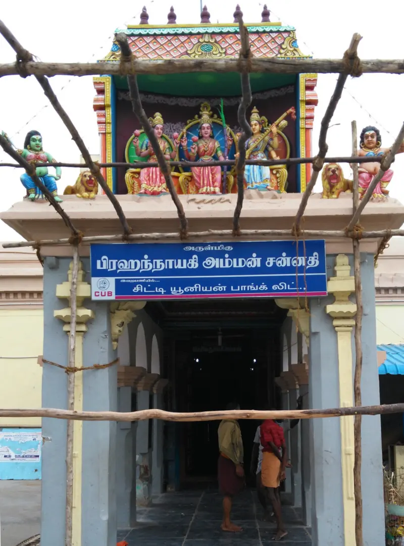 Shrine doorway with goddess statues on top and scaffolding poles