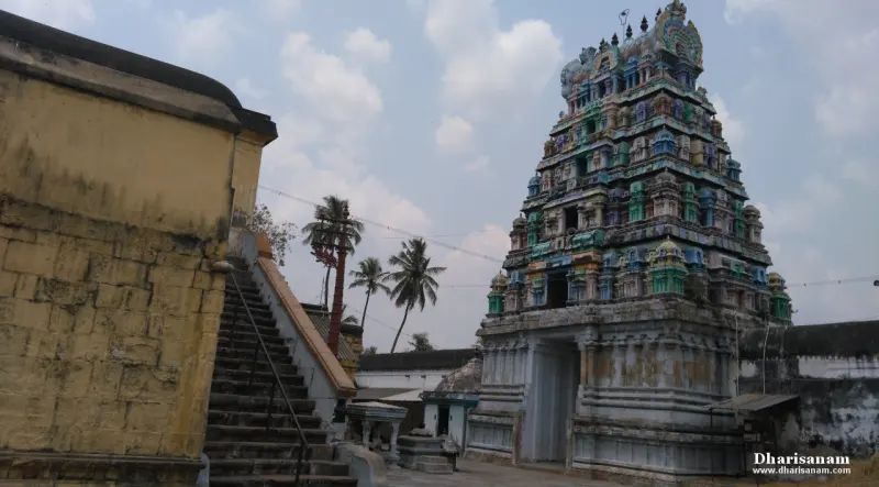 Stone steps climbing beside a wall to a small sculpted gopuram