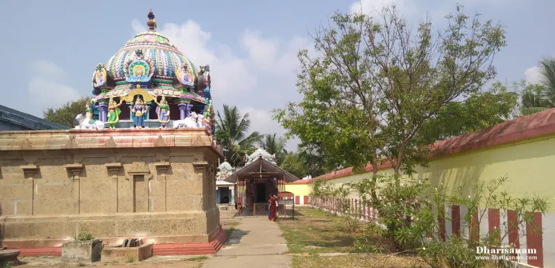 A colourful tower with figures above a stone shrine