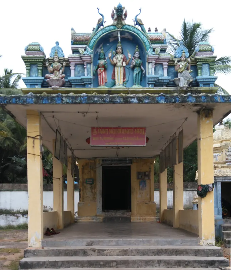 A yellow-pillared porch with a red name board and painted figures of goddesses and a deity above.