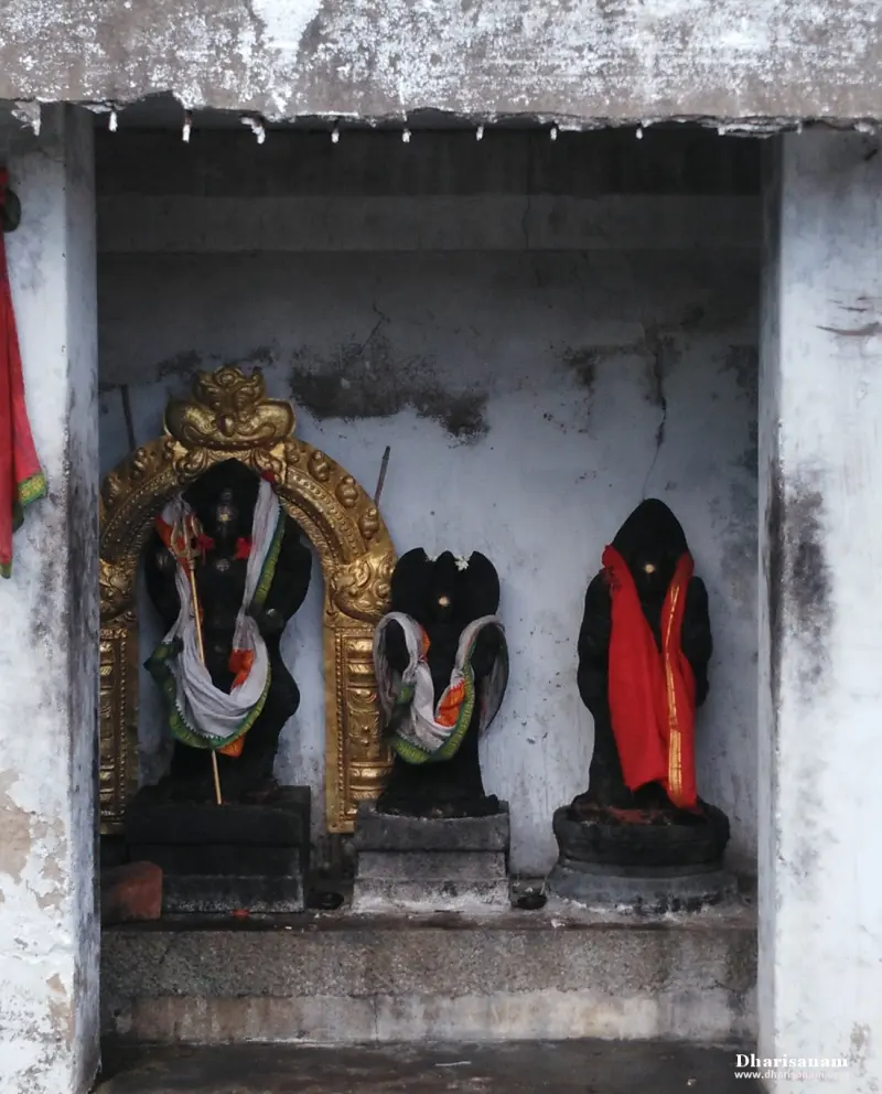 Three dark idols in cloth, the left one under a golden arch.