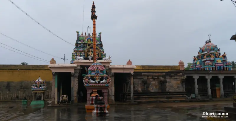 Tall flagstaff before the entrance hall, with a painted tower and a small shrine at the left