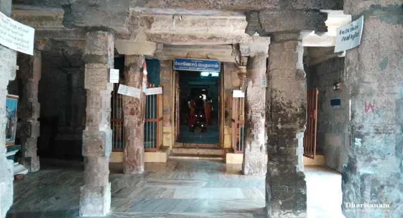 Stone pillars framing a dark doorway with lamps inside