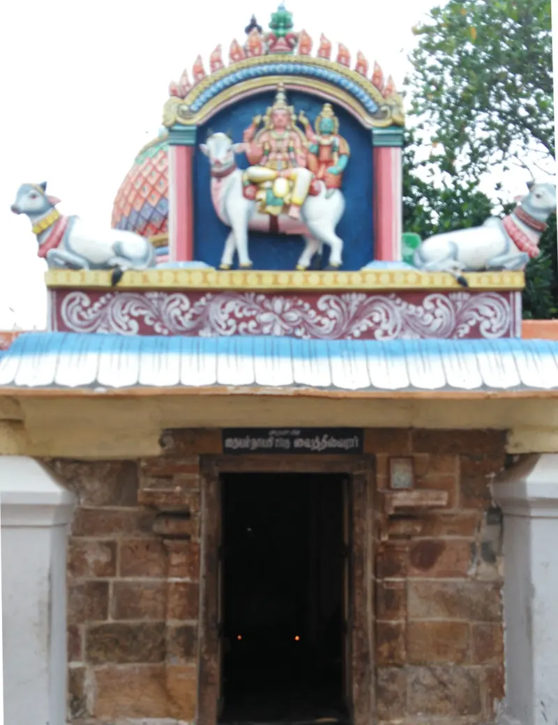 Stone doorway topped by painted gods on a bull between two Nandis