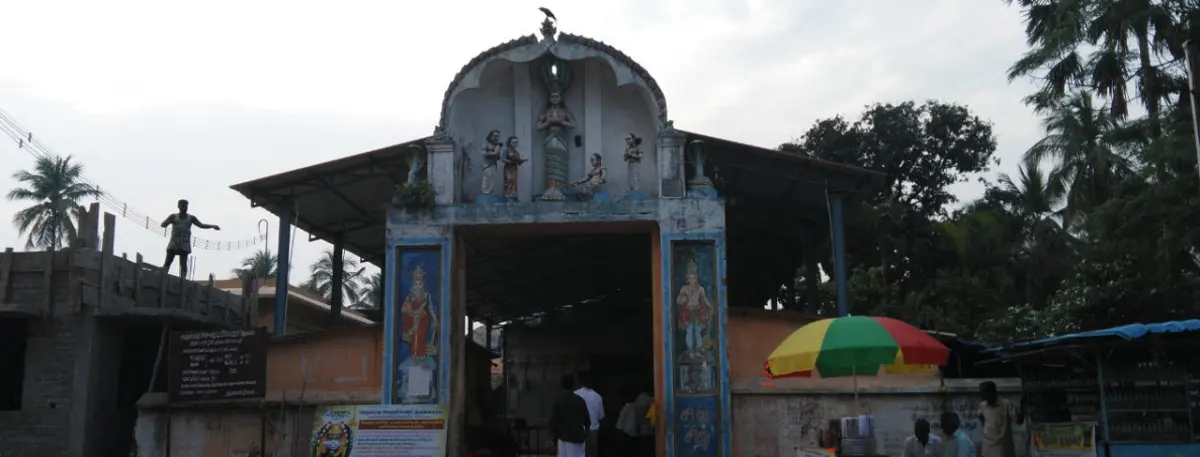 Entrance porch of the temple with painted figures on its pillars and a small gable above.