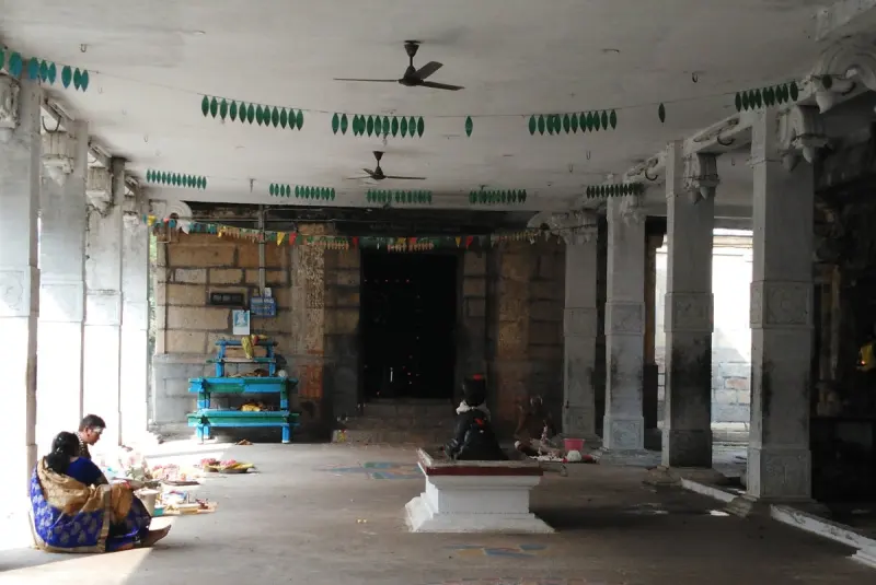Devotees sitting and praying inside a pillared hall