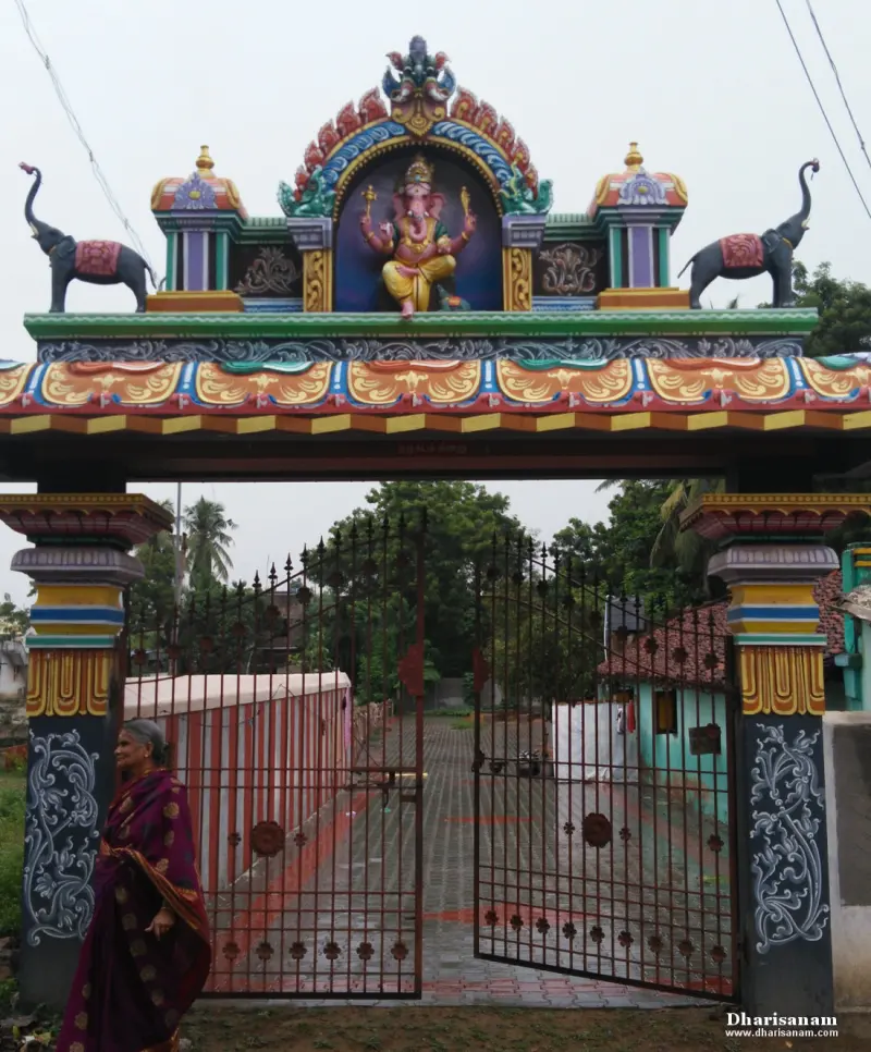 Gateway arch topped by a painted Vinayakar flanked by two elephants, with an iron gate below