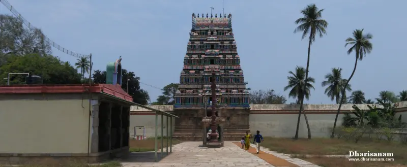 Tower at the end of a paved courtyard with two devotees walking