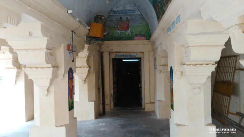 White pillared passage ending in a dark doorway, with colourful paintings on the ceiling above it